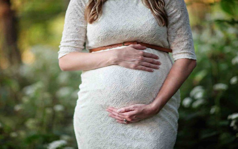 Kobieta w ciąży w białej sukience