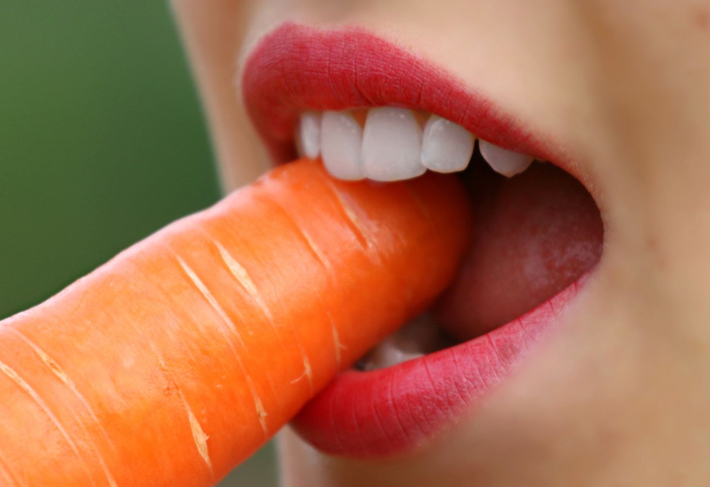 Kobieta gryząca marchewkę