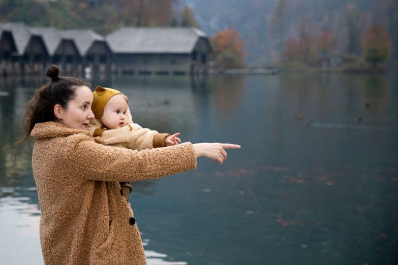 Kobieta nad jeziorem z dzieckiem na ręku