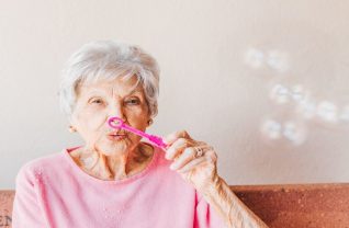 Starsza kobieta robiąca bańki mydlane