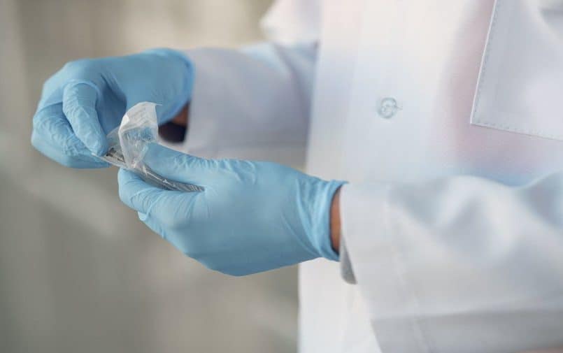 Osoba w laboratorium w sterylnych rękawiczkach