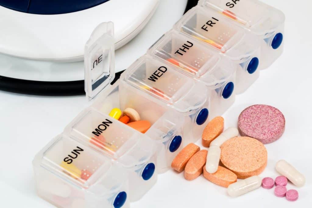 Pudełko na leki z kolorowymi tabletkami w środku