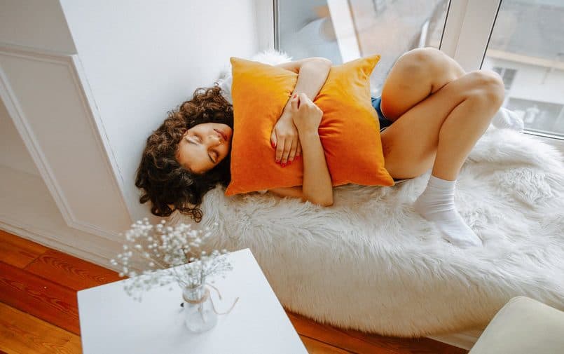 Kobieta na kanapie ściskająca poduszkę