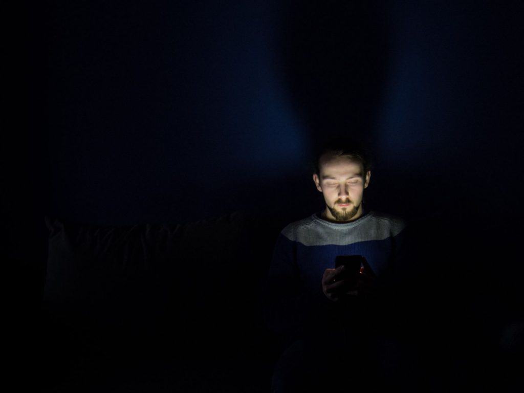 Mężczyzna przed laptopem w ciemnym pokoju
