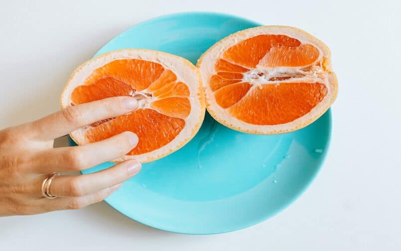 Kobieta dotykająca przekrojonej pomarańczy