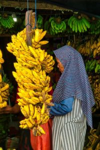 Indonezyjka obok kiści bananów