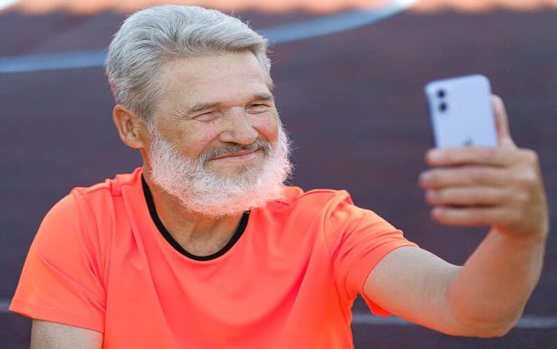 Uśmiechnięty senior ze smartfonem
