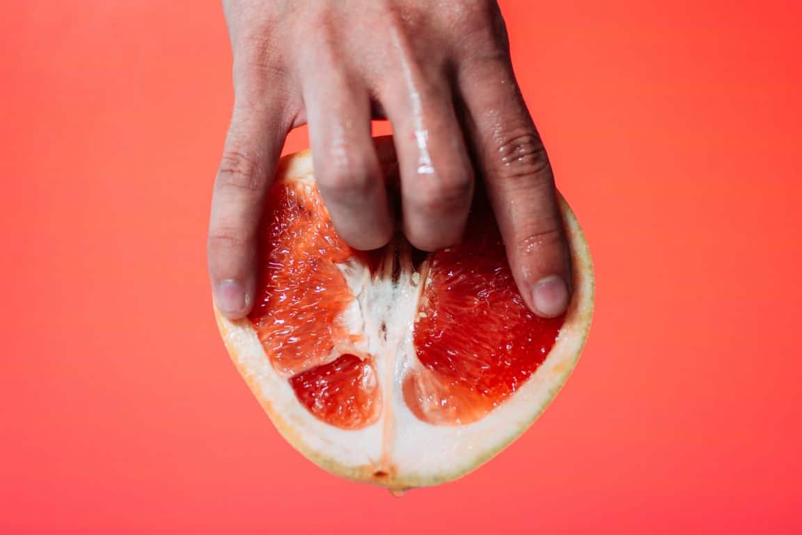 Dłoń i połówka pomarańczy